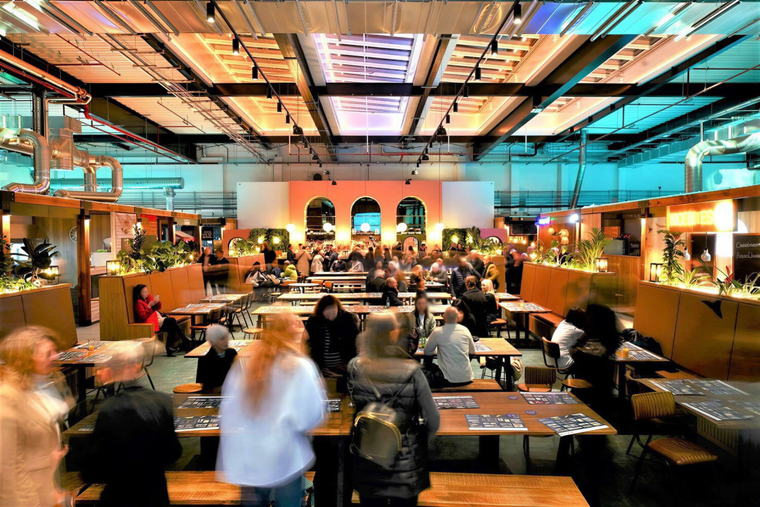 Indoor food market hall at Chester Northgate, with exposed services and a central rooflight above communal dining